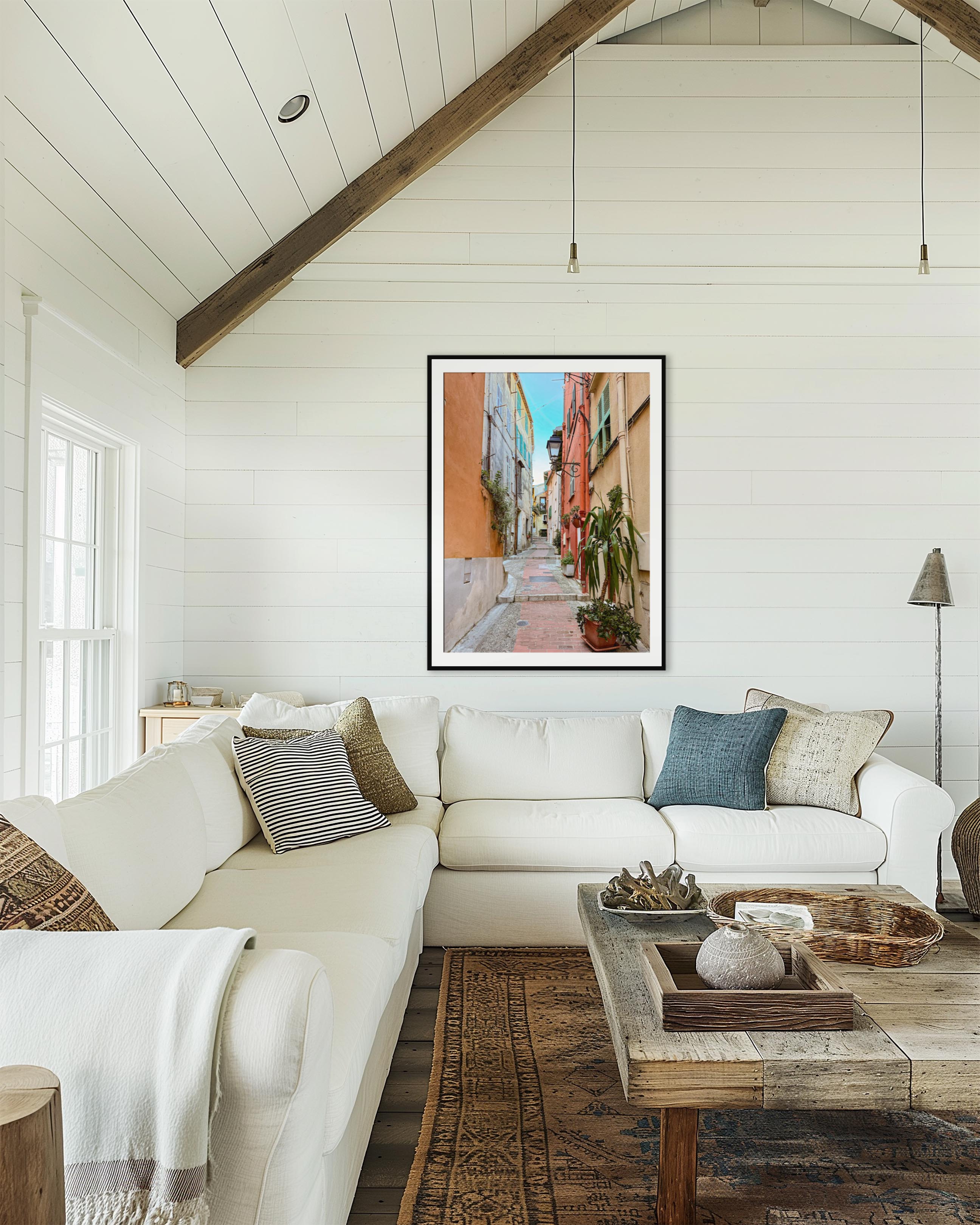 Living room with white sofa, wooden coffee table, and framed artwork on the wall.