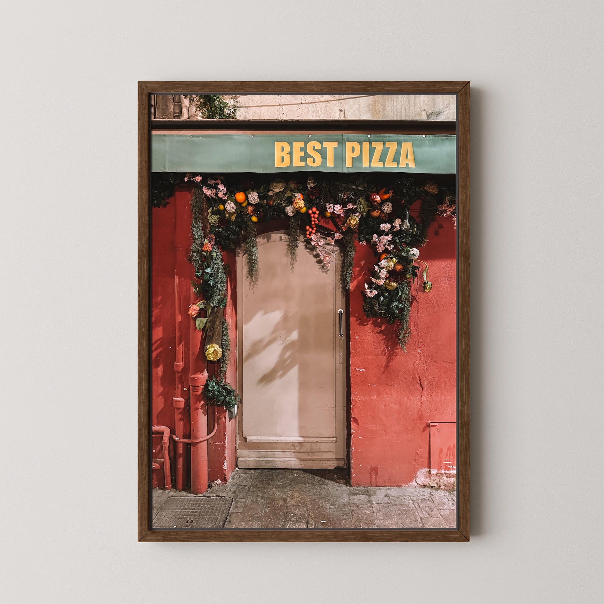 Framed photo of a pizza shop entrance with 'Best Pizza' sign and floral decorations.