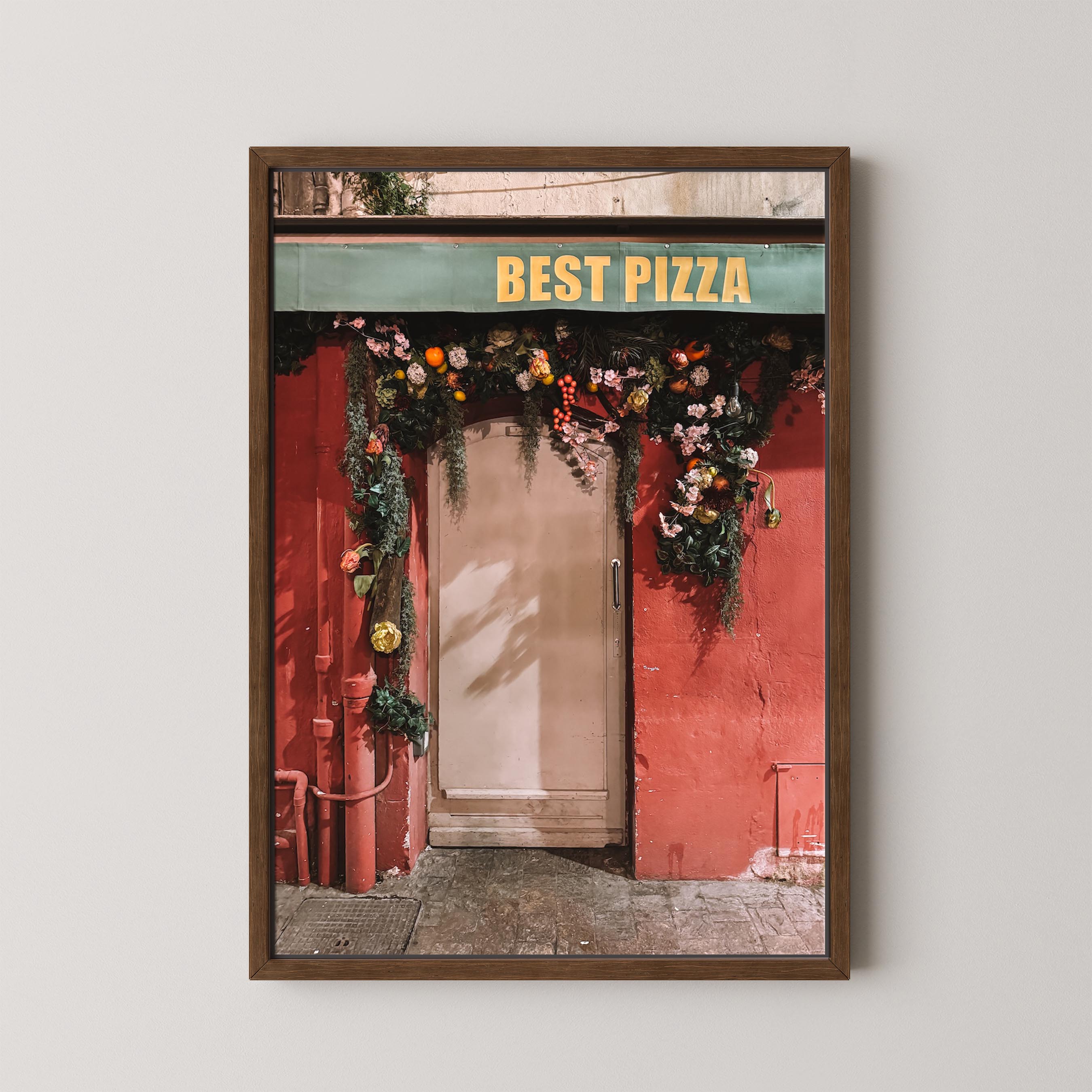 Framed photo of a pizza shop entrance with 'Best Pizza' sign and floral decorations.