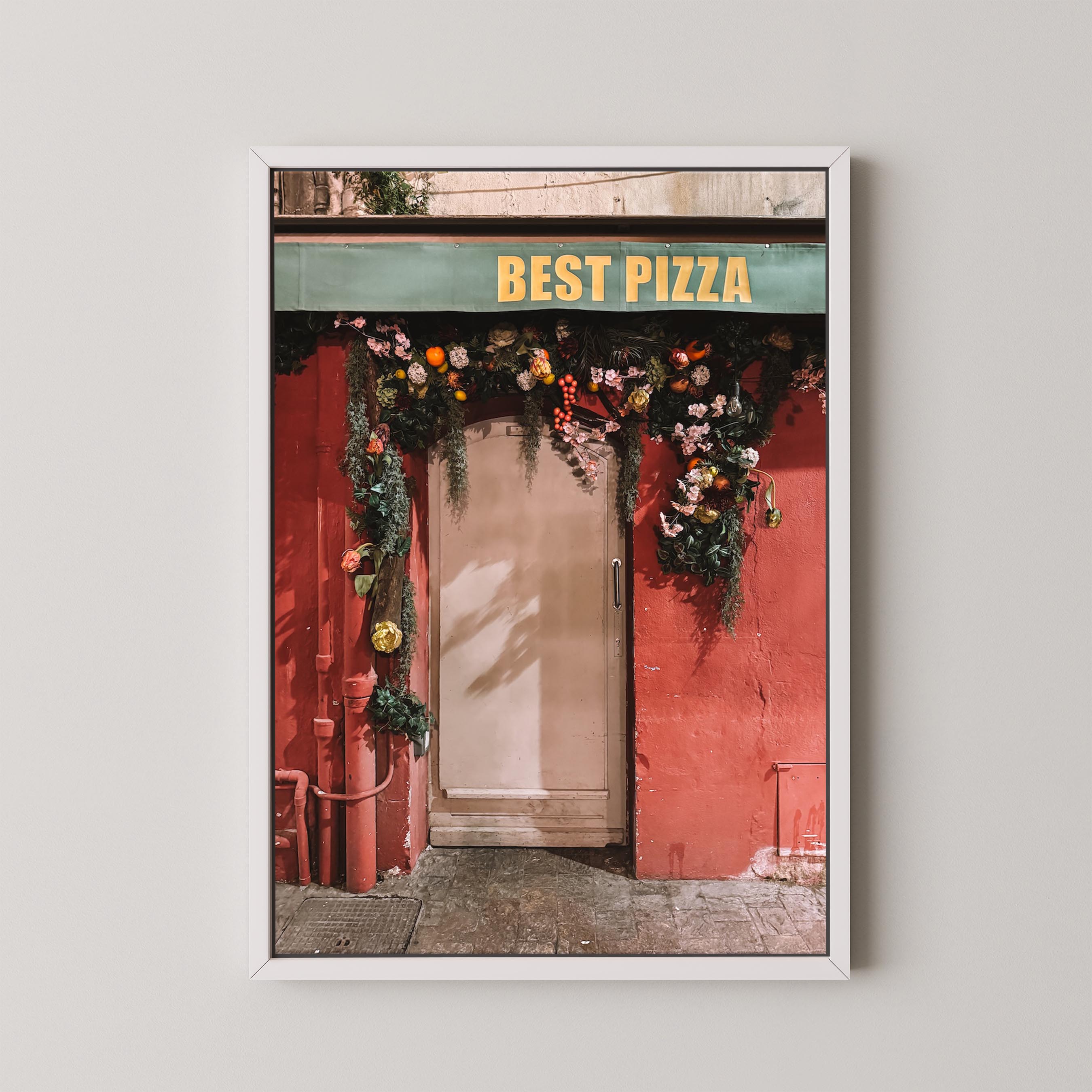 Framed photograph of a red building with 'Best Pizza' sign and floral decorations.