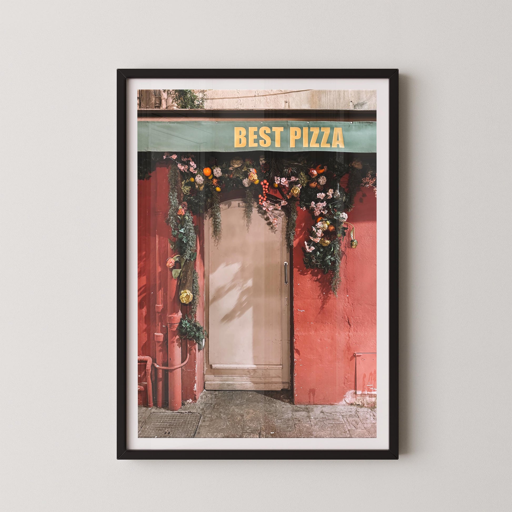 Framed print of a pizza shop entrance with 'Best Pizza' sign and floral decorations.