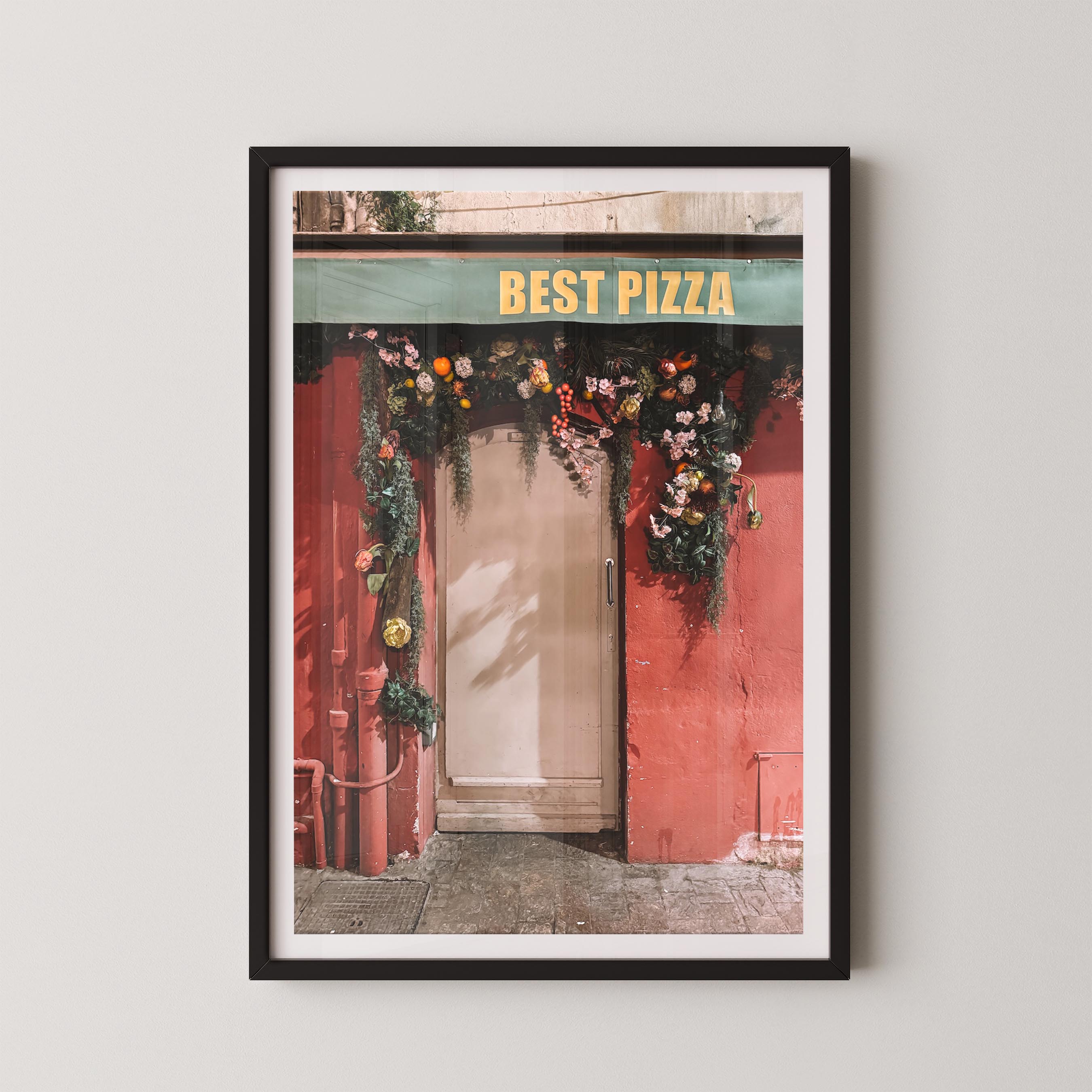 Framed print of a pizza shop entrance with 'Best Pizza' sign and floral decorations.