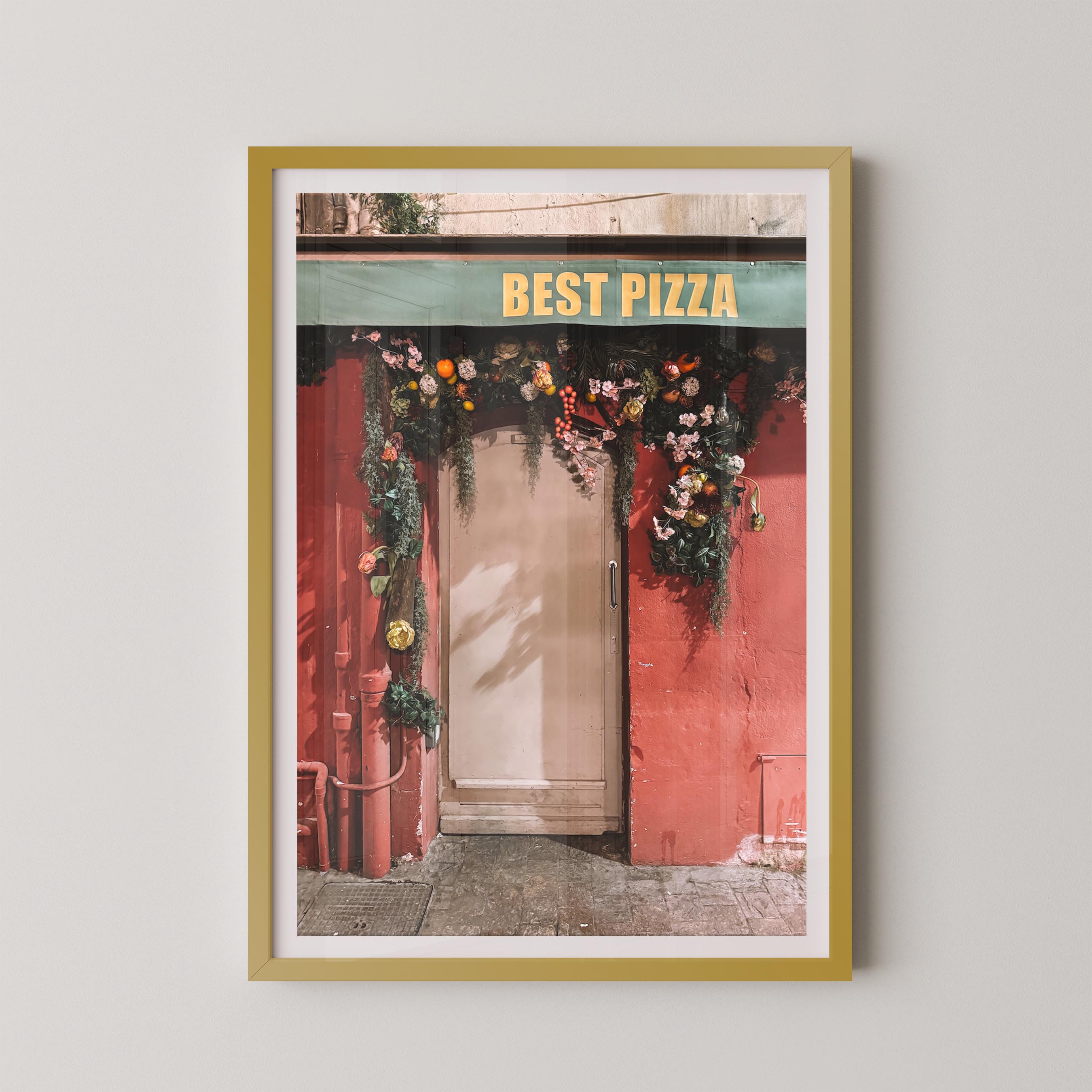 Framed photo of a pizza shop entrance with floral decorations and 'Best Pizza' sign.