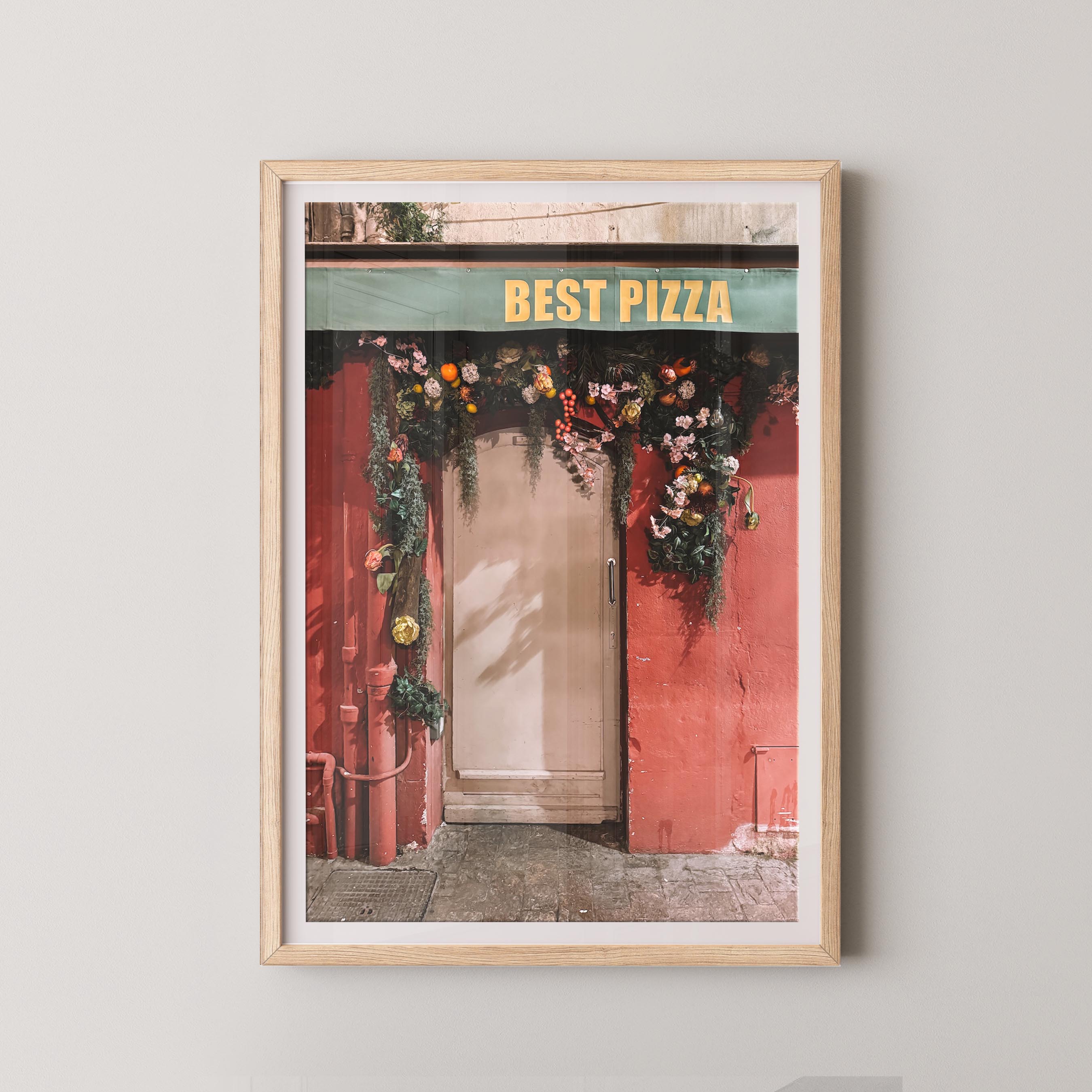 Framed print of a French pizza shop entrance with 'Best Pizza' sign on a white wall