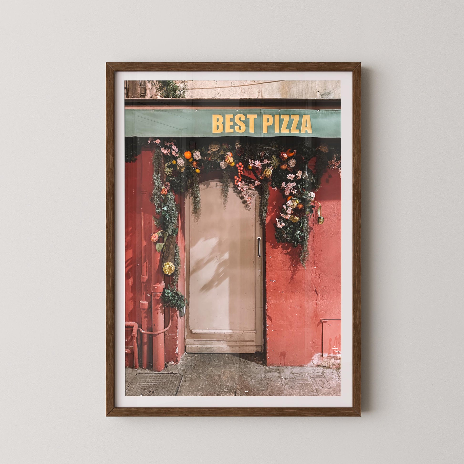 Framed print of a pizza shop entrance with 'Best Pizza' sign and floral decorations.