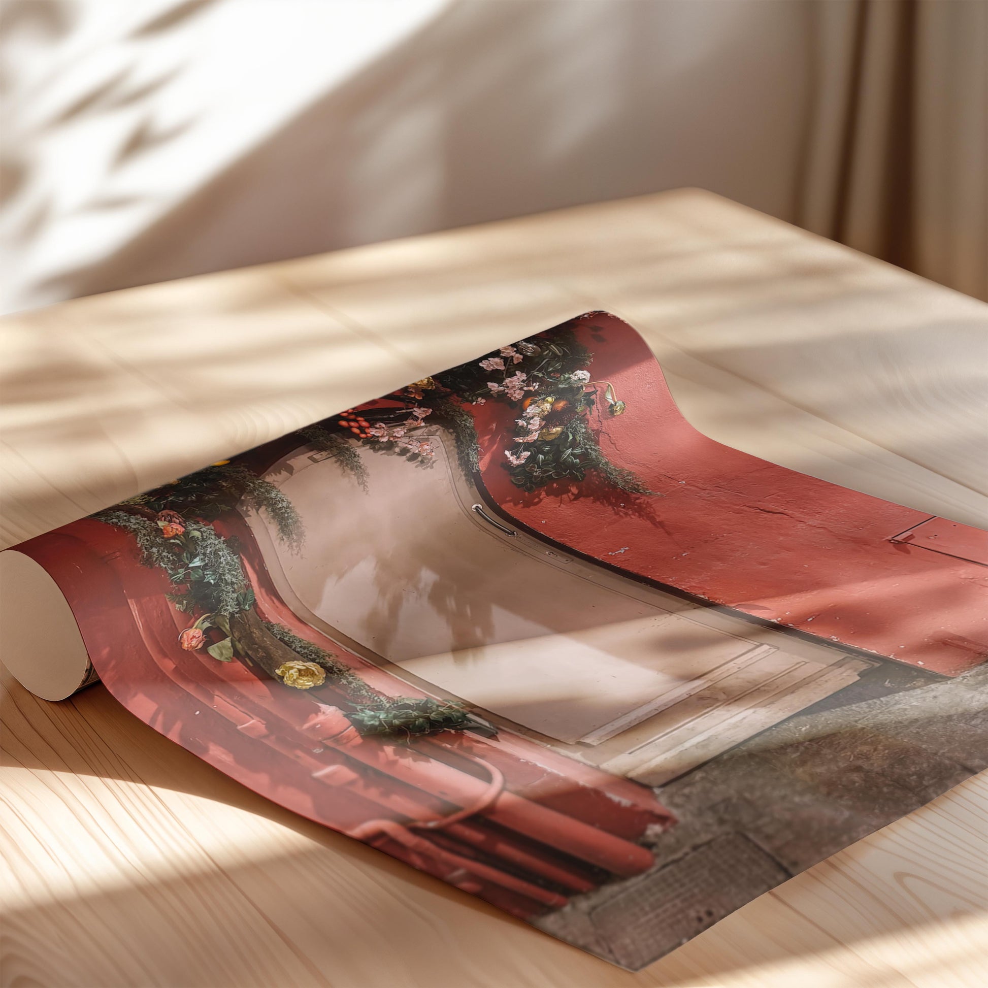 Roll of red paper with floral design on a wooden surface