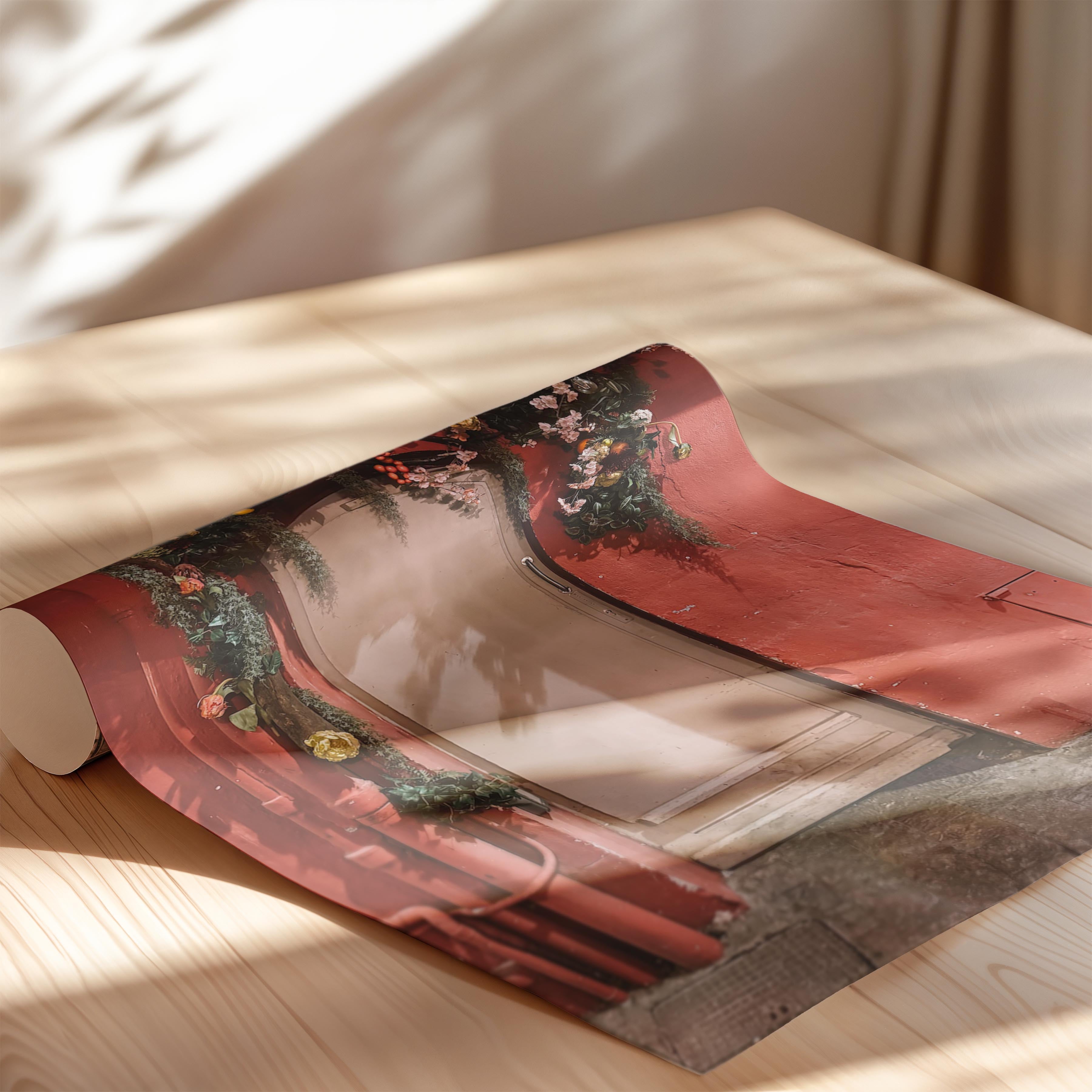 Roll of red paper with floral design on a wooden surface