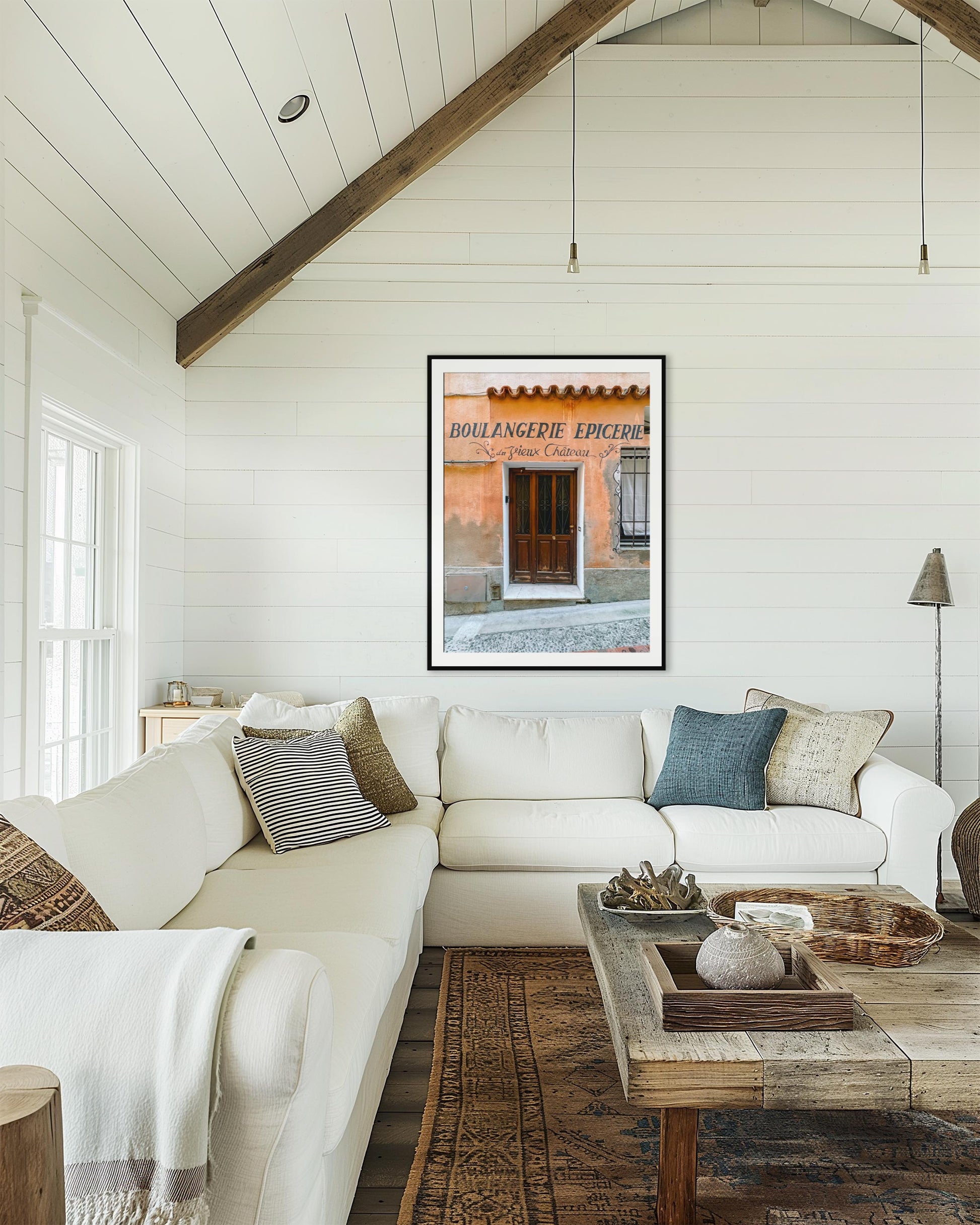 Living room with white sofa, wooden coffee table, and framed artwork on the wall.