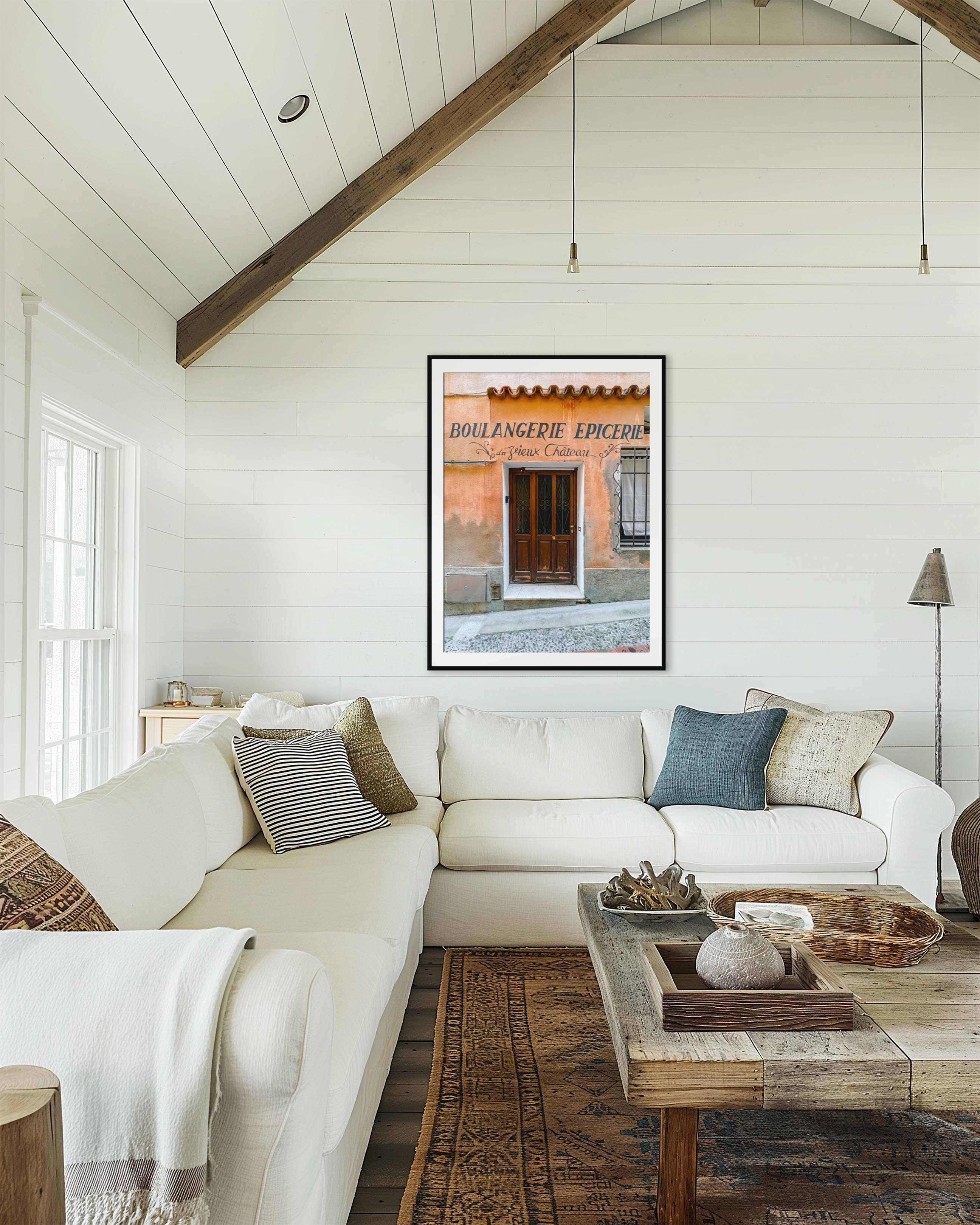 Living room with white sofa, wooden coffee table, and framed artwork on the wall.