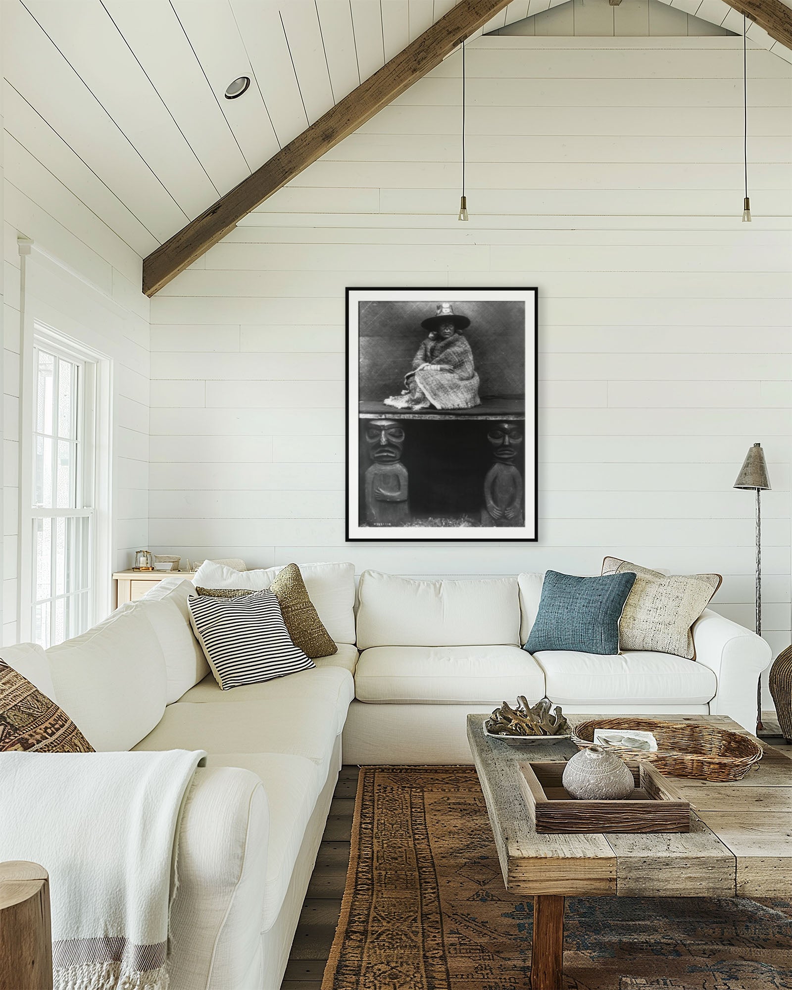 Cozy living room with white sofa, wooden coffee table, and framed artwork on the wall.
