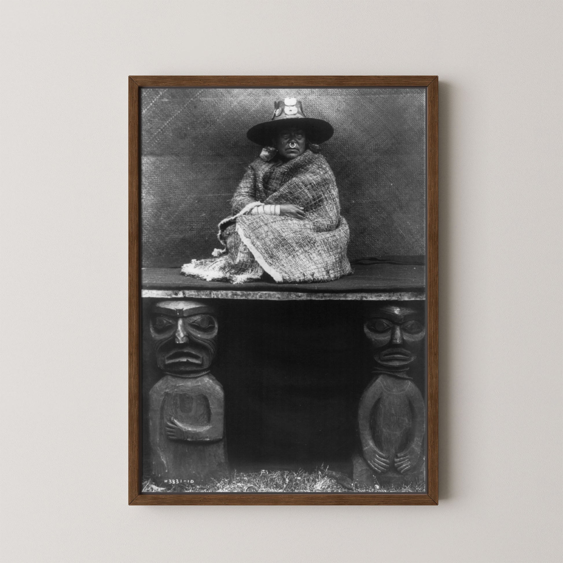 Framed black and white portrait of a person sitting on a bench with decorative elements below.