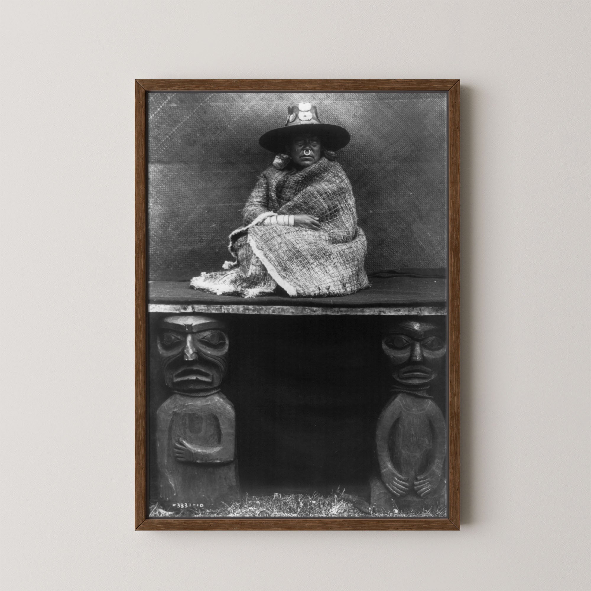 Framed black and white portrait of a person sitting on a bench with decorative elements below.